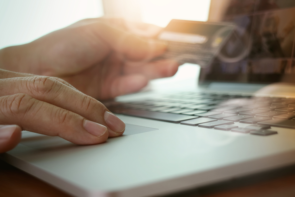 close up of hands using laptop and holding credit card as Online shopping concept close up of hands using laptop and holding credit card as Online shopping concept